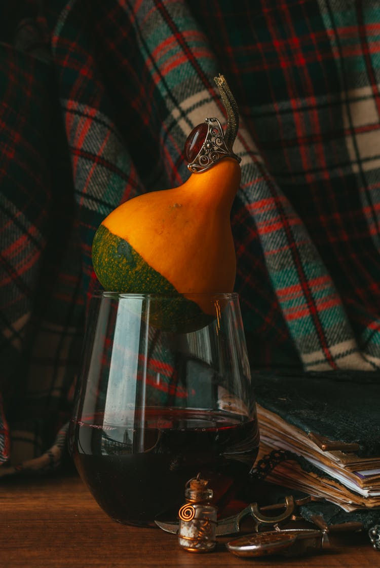 Pile Of Ring, Pumpkin And Wineglass Of Red Wine