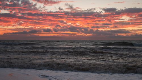 Free Capture the beauty of a dramatic ocean sunset with vivid crimson clouds and the serene sea. Stock Photo