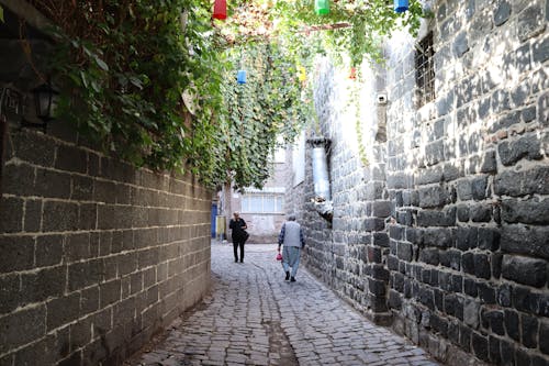 People Walking in Brick Narrow Alley 