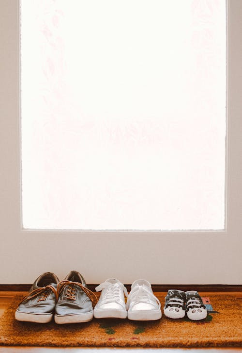 Free Three Pairs of Shoes on Brown Rug Stock Photo