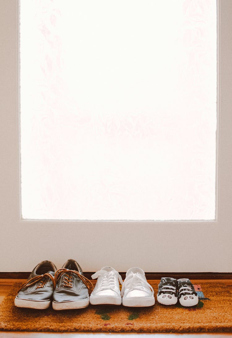 Three Pairs Of Shoes On Brown Rug