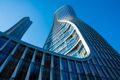 Free Dynamic view of Raffles City Hangzhou showcasing its innovative architectural design against a clear blue sky. Stock Photo