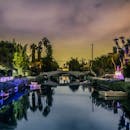 夜晚的运河倒映着灯光、桥梁和树木，一片宁静