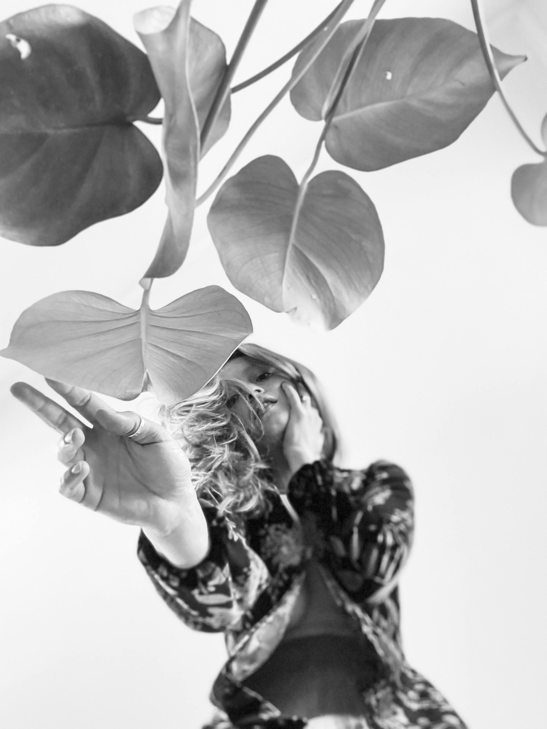 Woman Standing behind Leaves in Black and White · Free Stock Photo