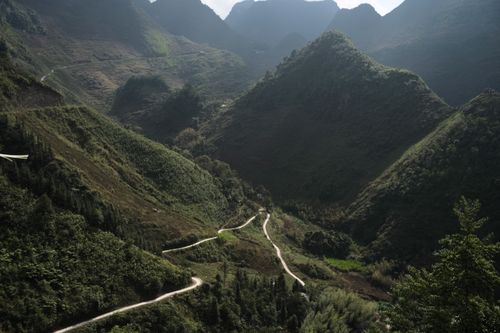 Free Explore a winding road through lush green mountains, ideal for adventure travelers. Stock Photo