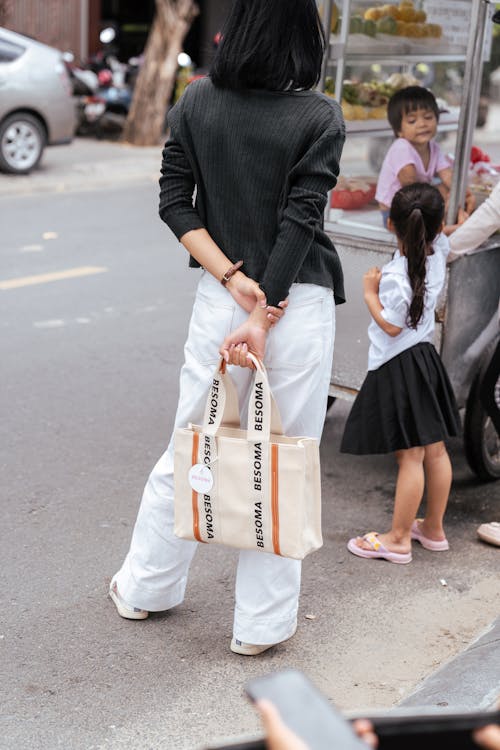 Brunette in White Pants Holding a Bag