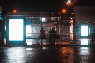 Bus shelter at night with two blank illuminated poster panels