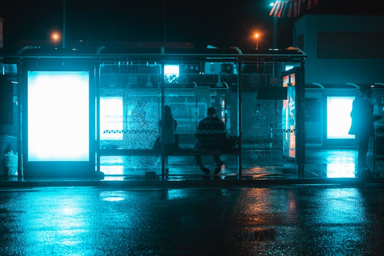 People On A Bus Stop At Night 