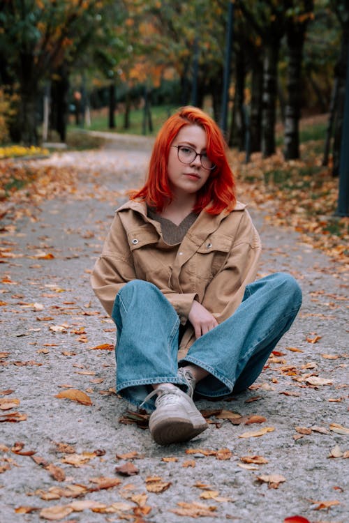Woman in Dyed Red Hair and Beige Jacket Standing Sitting in Autumn Park