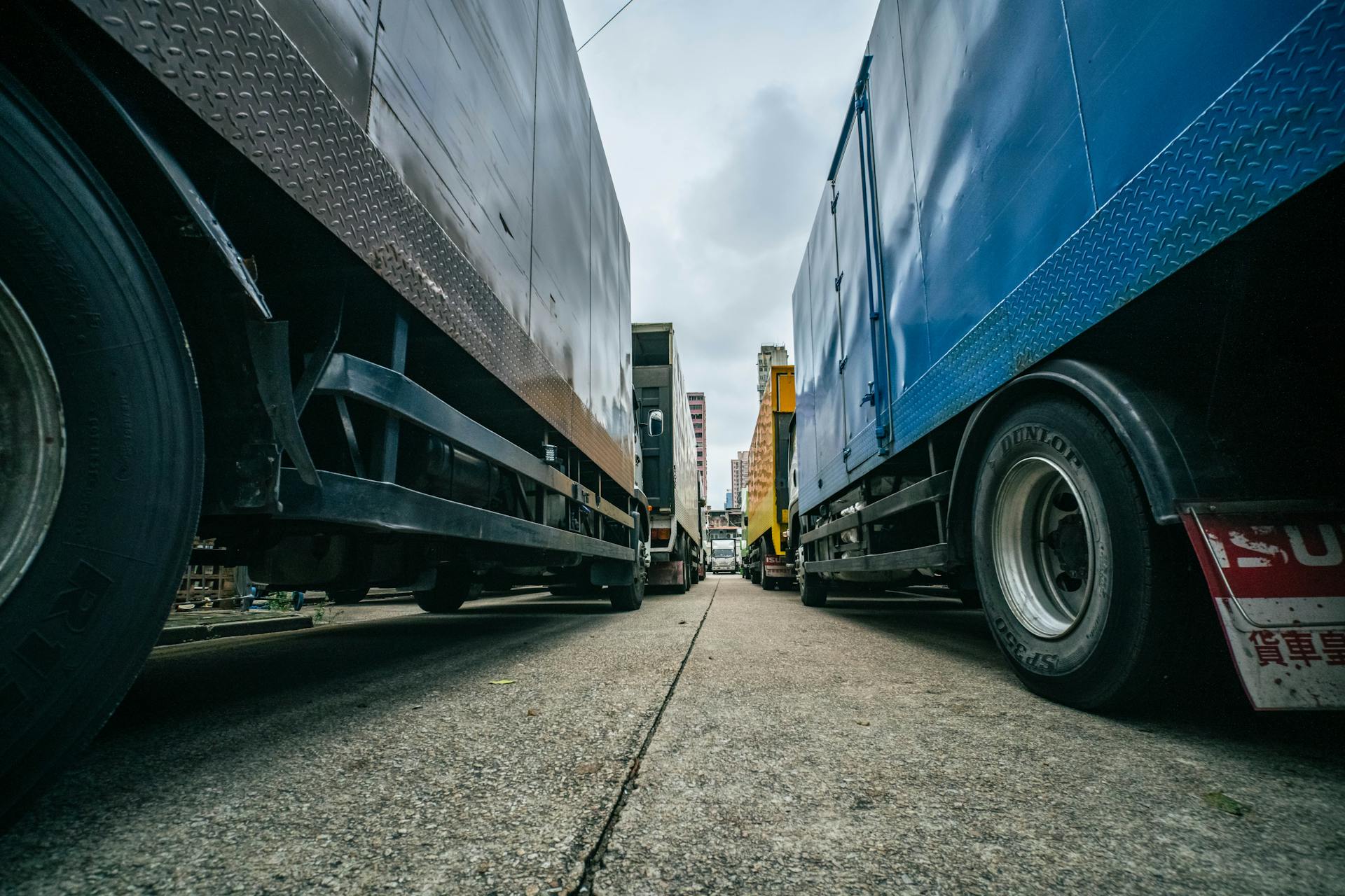 Captivating low-angle perspective of multiple trucks lined up on a street in Hong Kong.