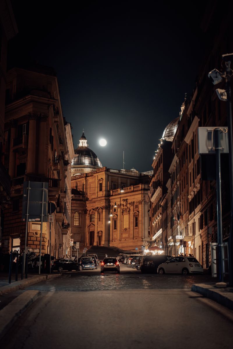 Moon in night sky over alley in Rome, Italy