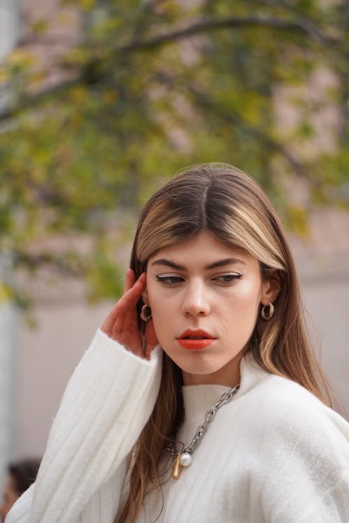 Photo of a Woman Wearing a White Sweater and Red Lipstick