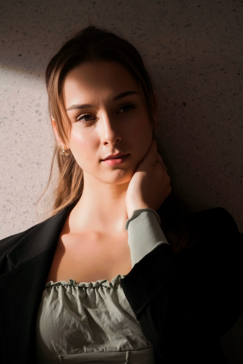 Free A young woman in Berlin poses thoughtfully in natural light against a textured wall. Stock Photo
