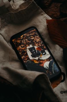 Smartphone displaying a camera in autumn leaves, captured in Bolu, Türkiye.
