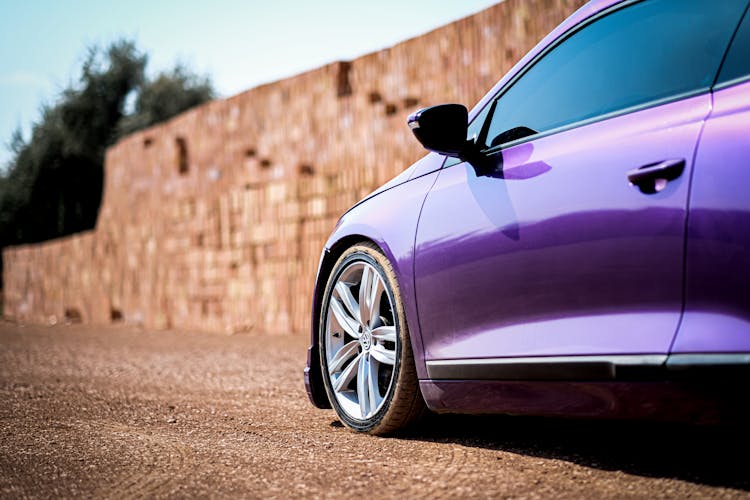 Closeup Of A Purple Car By A Brick Wall