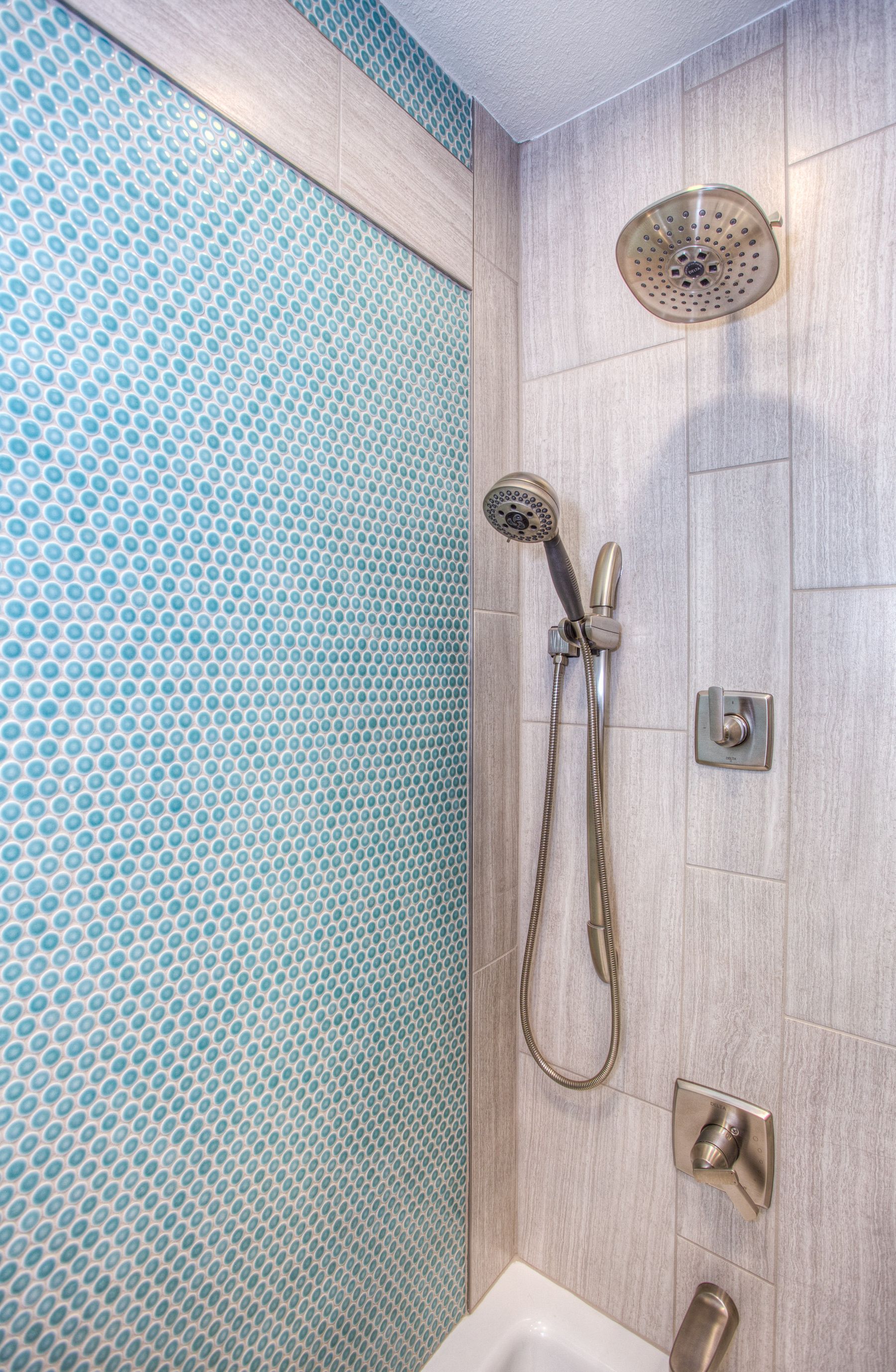 Fine blue mosaic tile paired with stainless fittings in a shower zone