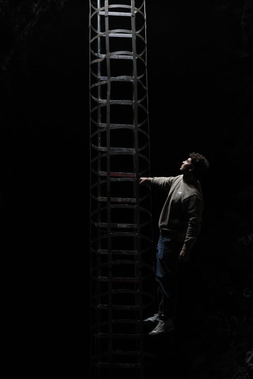 Black Photograph of a Man Standing by a Metal Construction