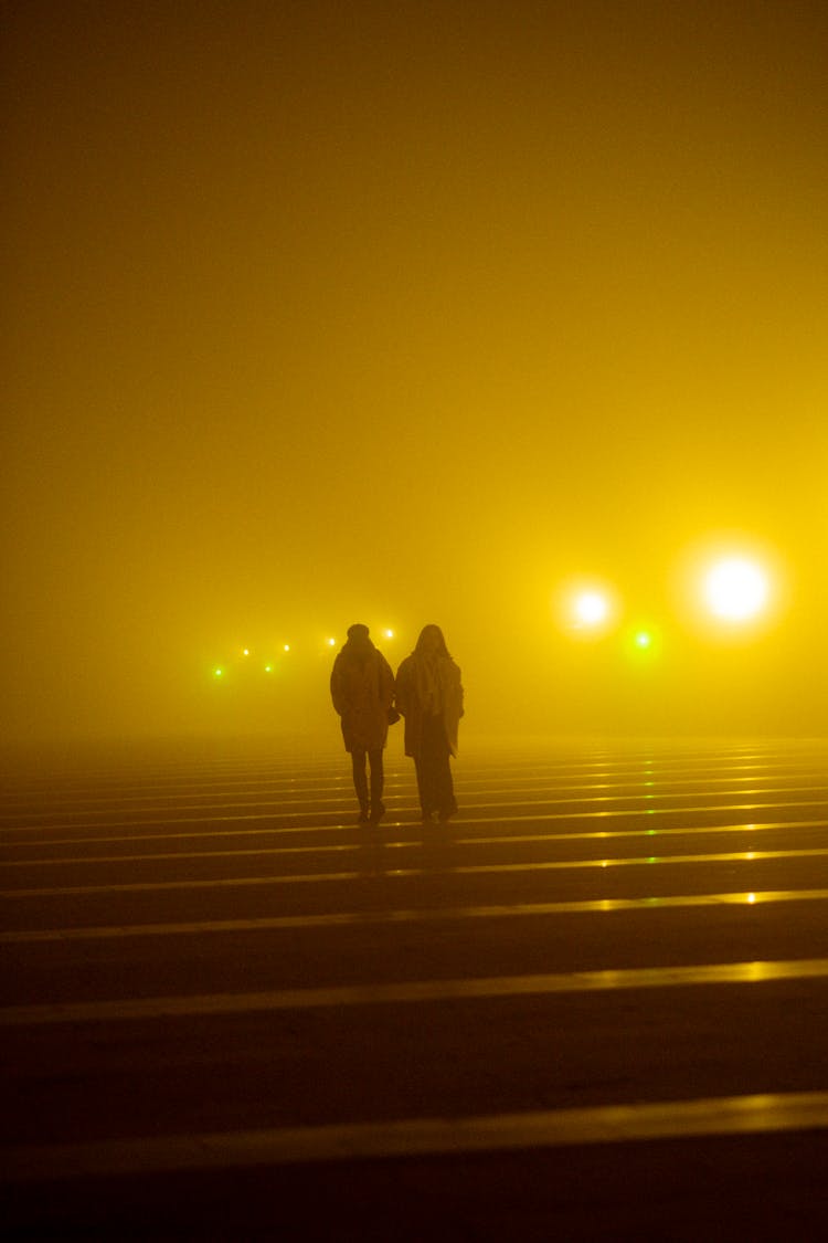 Silhouettes On Crosswalk At Foggy Night