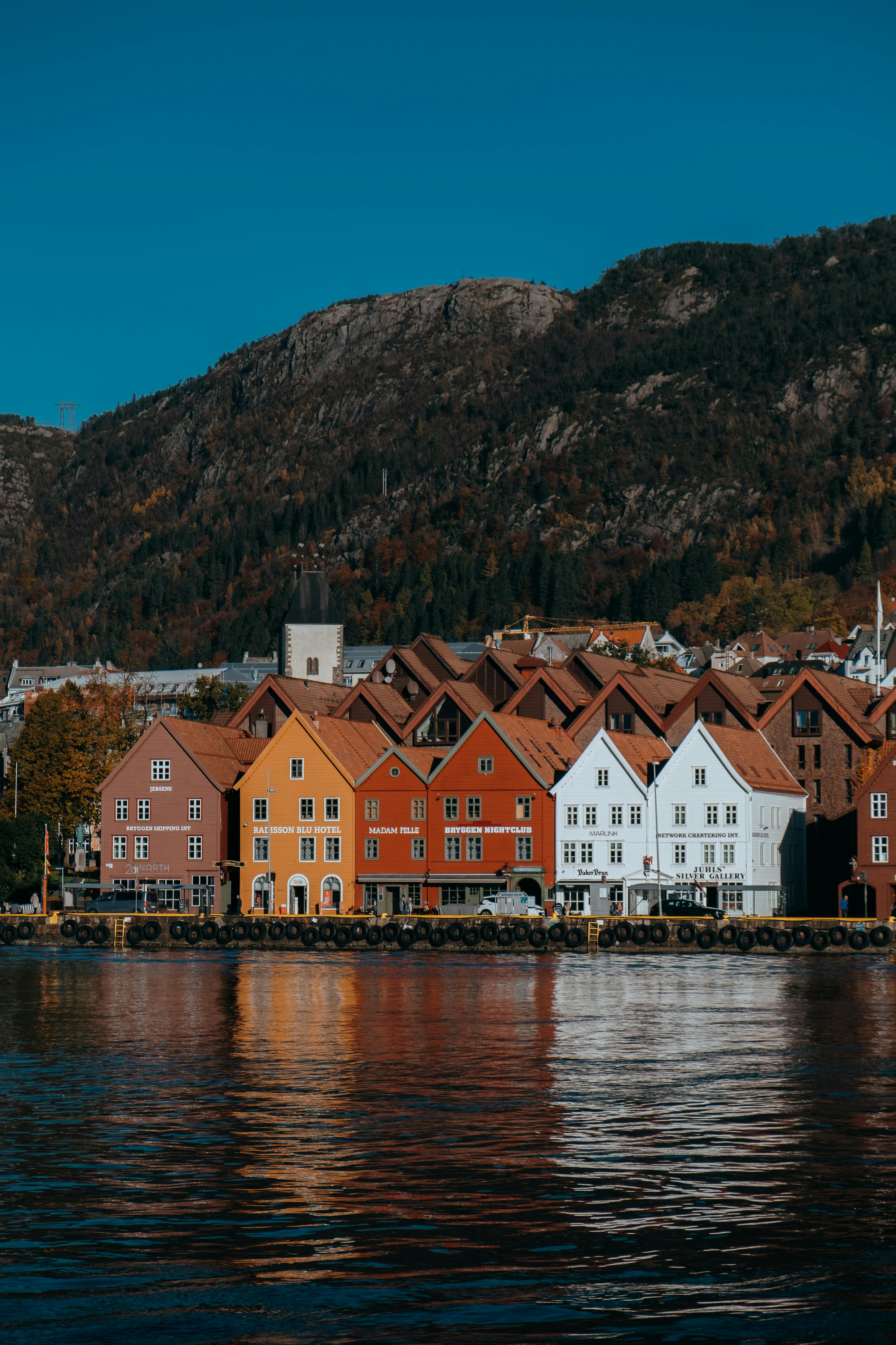Scenic view of Bryggen's historic trade houses in Bergen, reflected in the water.