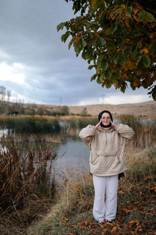 Smiling Woman in Hijab Standing on Lakeshore