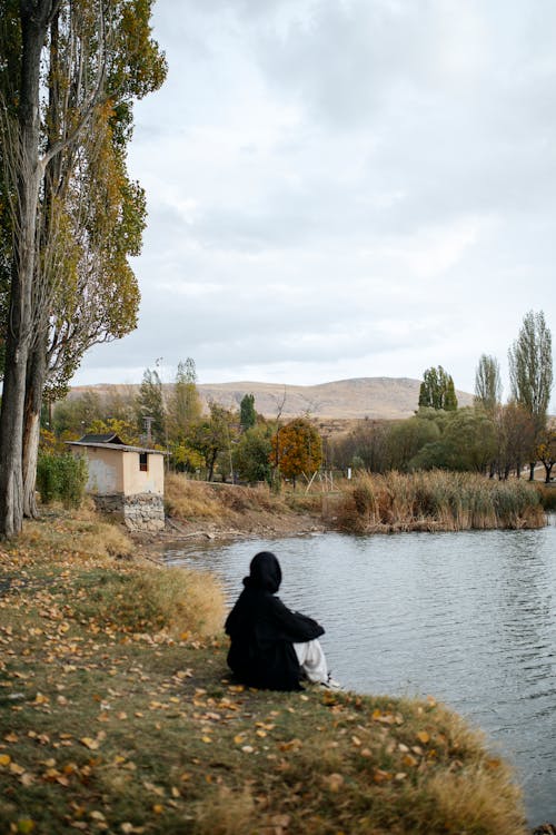 Hiker Sitting on the Riverbank
