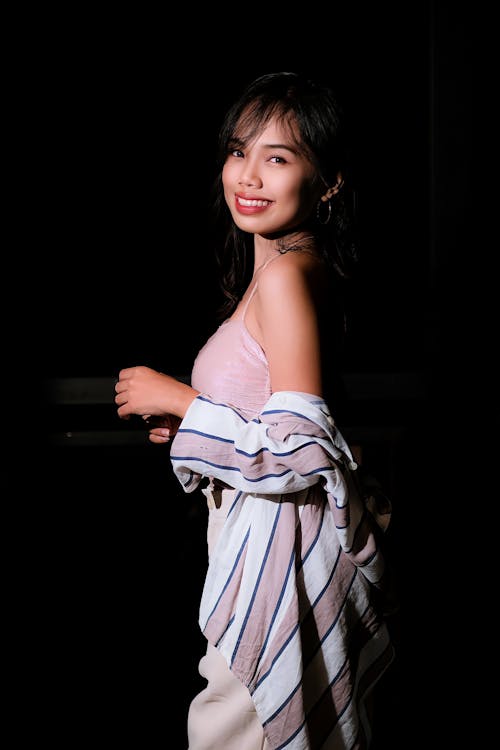 Smiling Young Woman in a Pink Dress and Striped Blouse