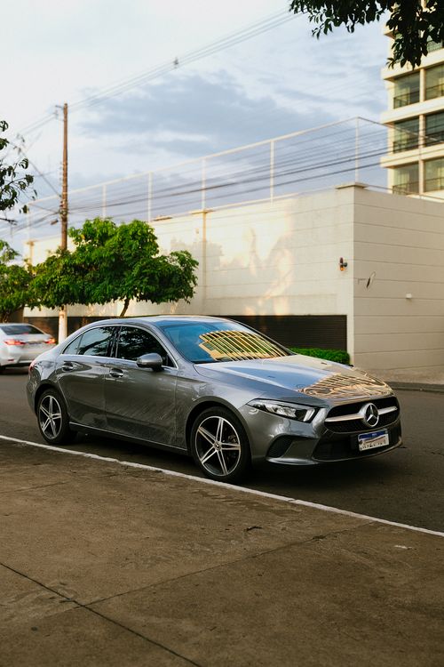 Free A sleek Mercedes sedan parked on an urban street under a clear sky. Stock Photo