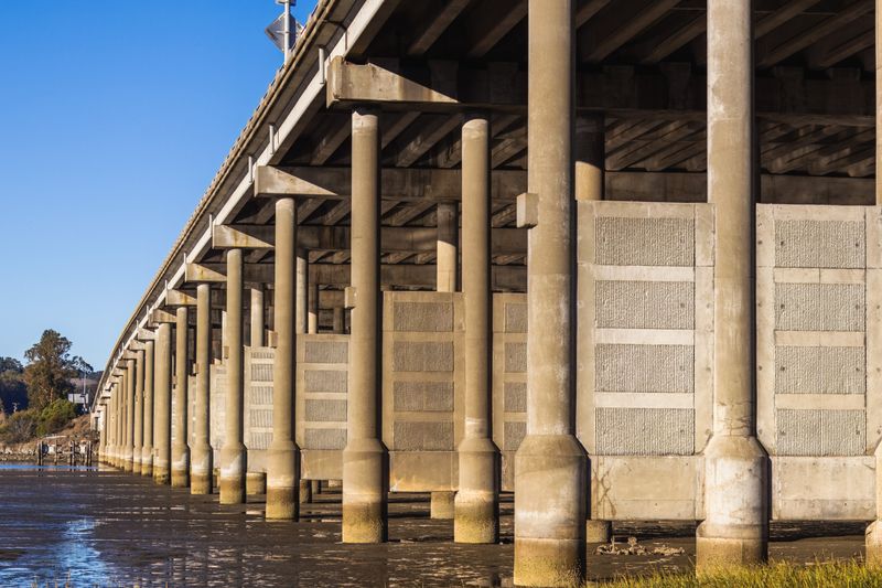 Concrete bridge pillars seen from below beside a river