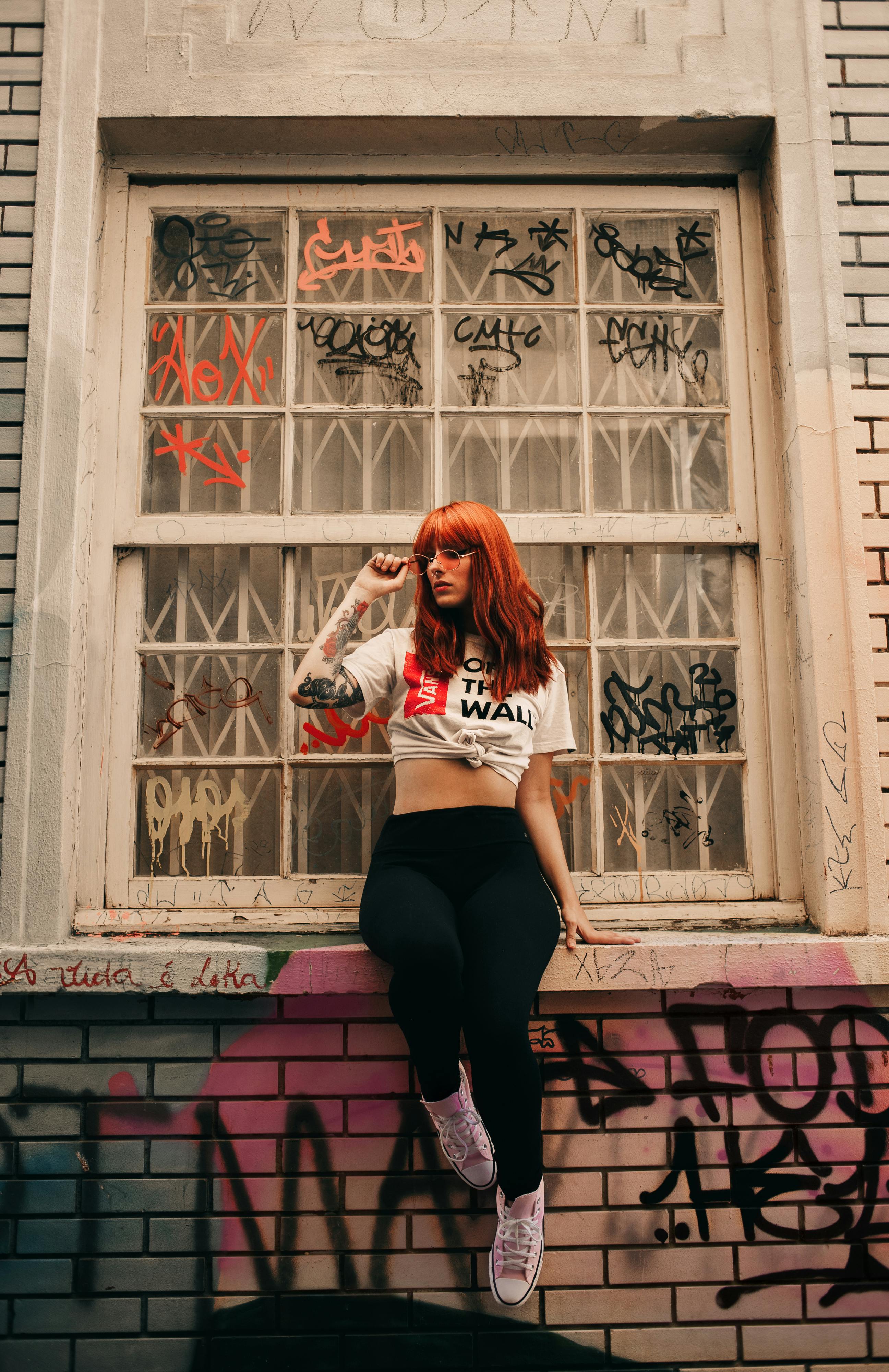 photo of posing woman sitting on window sill