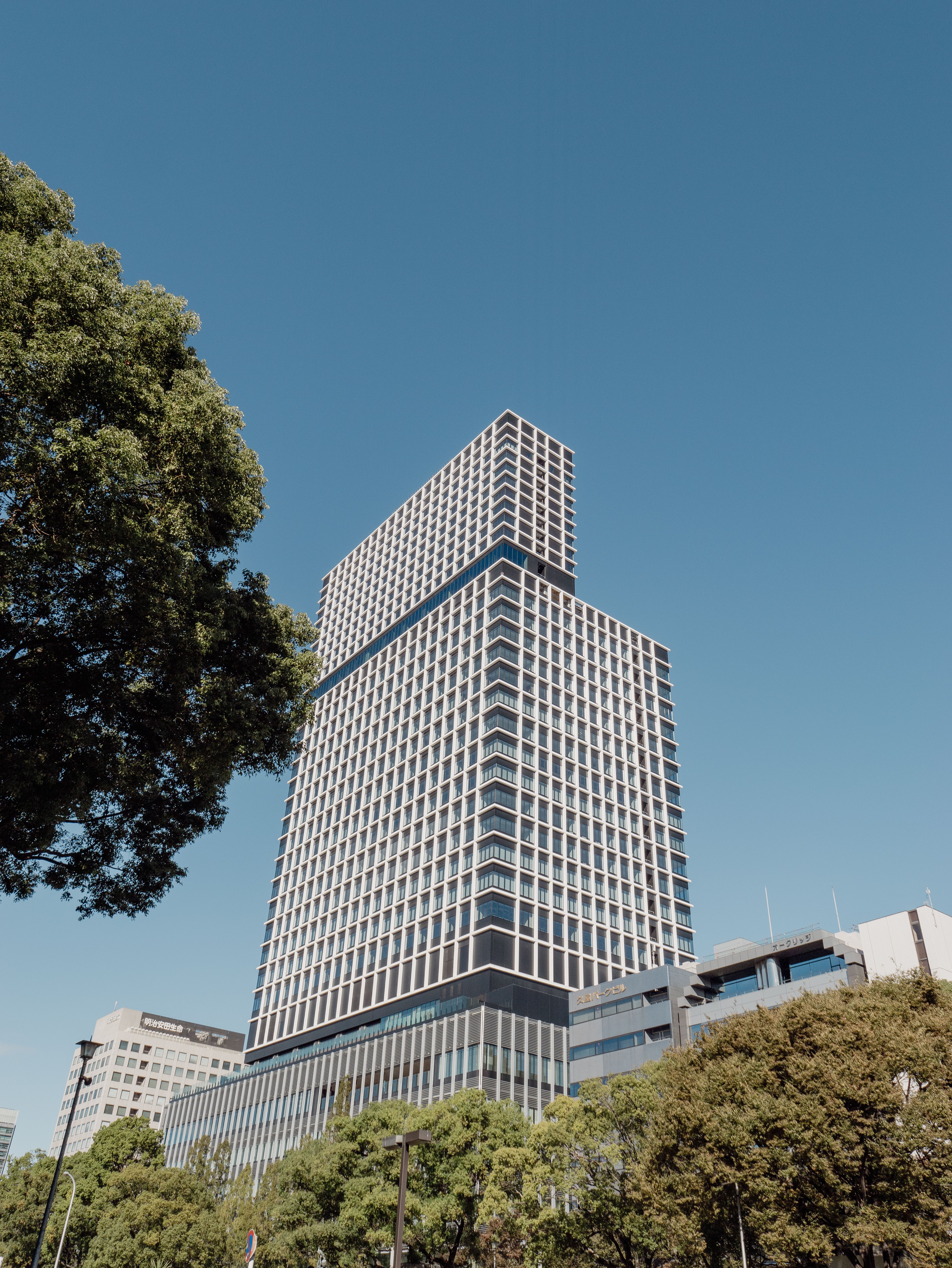 A striking view of a modern skyscraper in Nagoya, Japan on a sunny day.