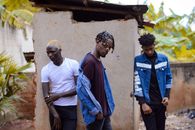 3 Men in White and Blue Shirts Standing by the Shanty