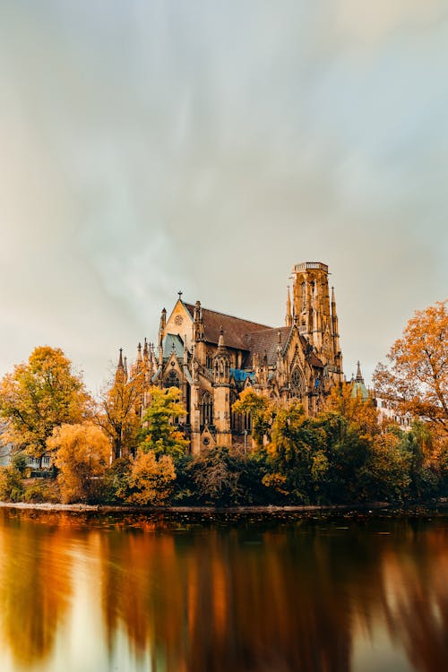 Gothic Historic Castle near Lake in Autumn Landscape