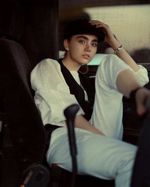 Woman Sitting in White Shirt and Ivy Cap