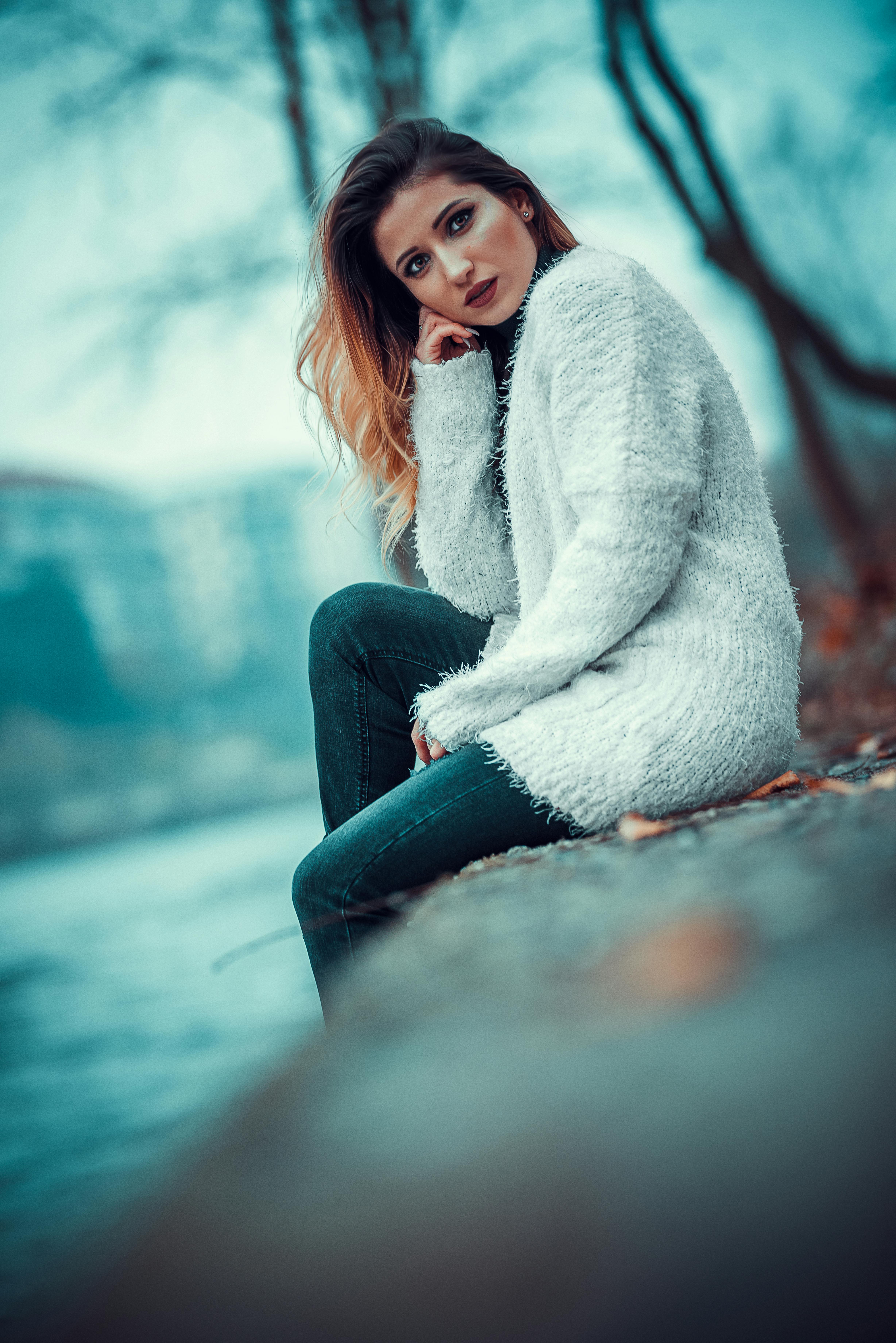 Photo Of Woman In White Sweater Sitting On Concrete Riverbank Images, Photos, Reviews