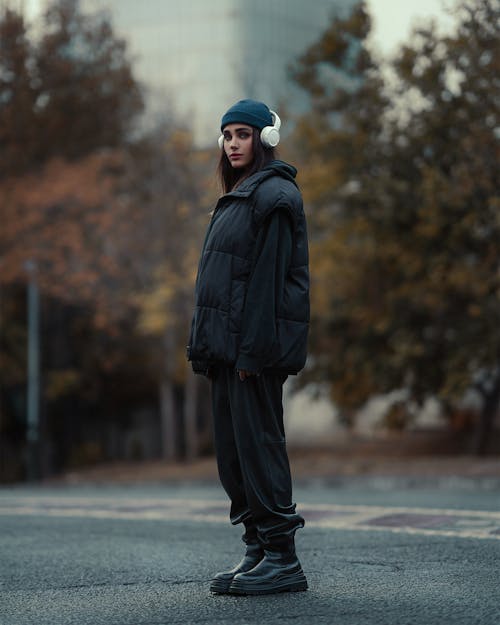 Young Woman in Puffer Jacket with Headphones