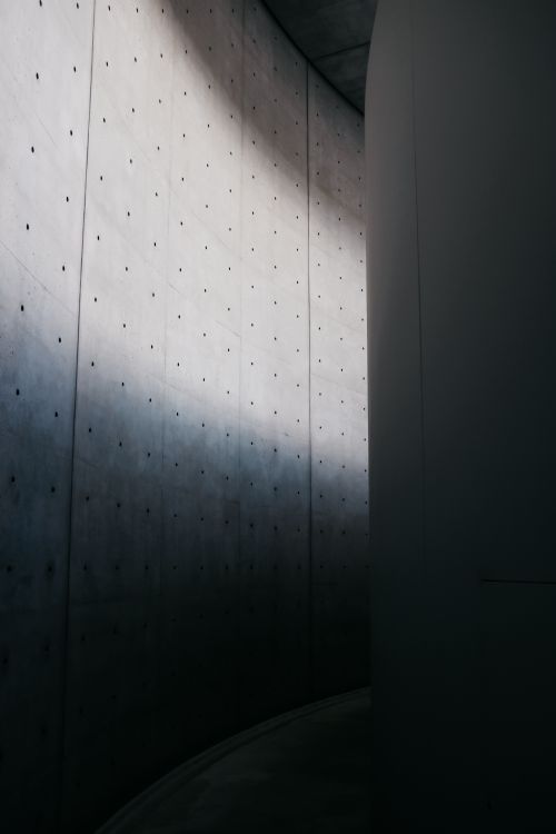 Free Abstract view of an urban concrete wall with dramatic shadows creating a moody atmosphere. Stock Photo