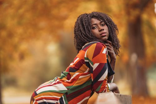 Free Stunning woman posing outdoors in fall with a colorful dress, capturing the essence of autumn fashion. Stock Photo
