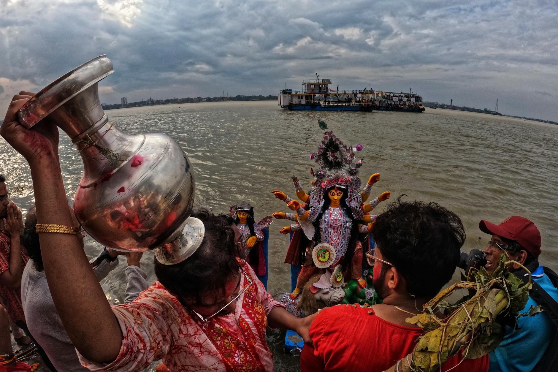 Capturing the colorful Durga Puja celebrations by the Ganges in Kolkata, India, with a focus on ritual and tradition.