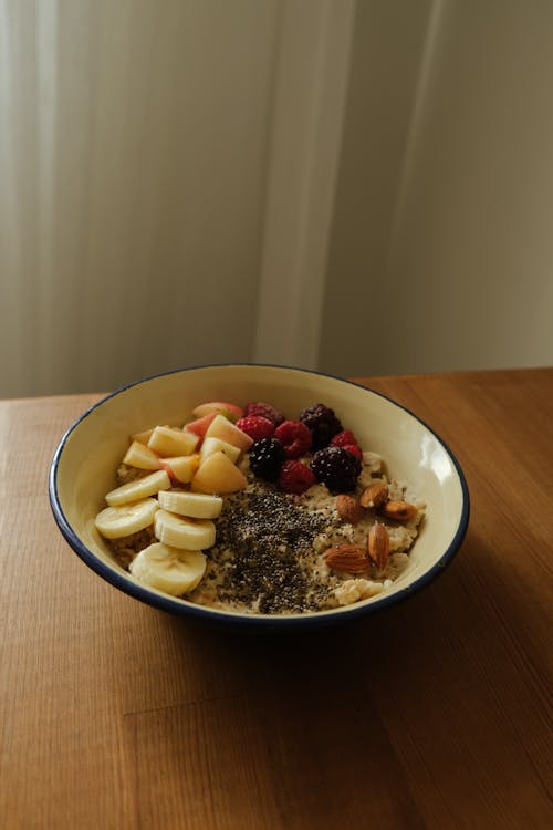 A Bowl of Oatmeal Topped with Fruits, Nuts and Seeds 