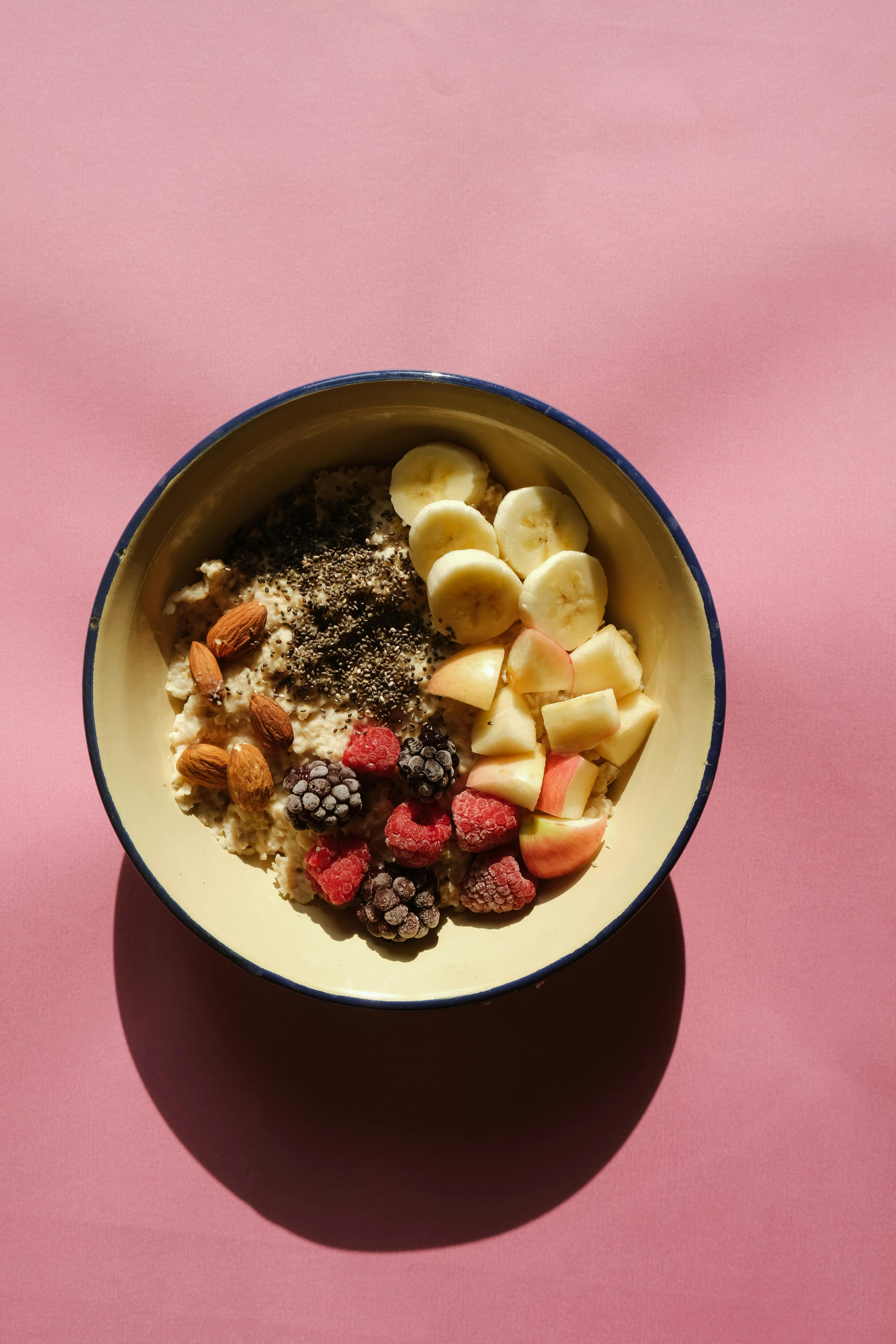 A breakfast bowl with oats, fruit, nuts and seeds, underscoring that baseline fiber intake begins with ordinary meals.