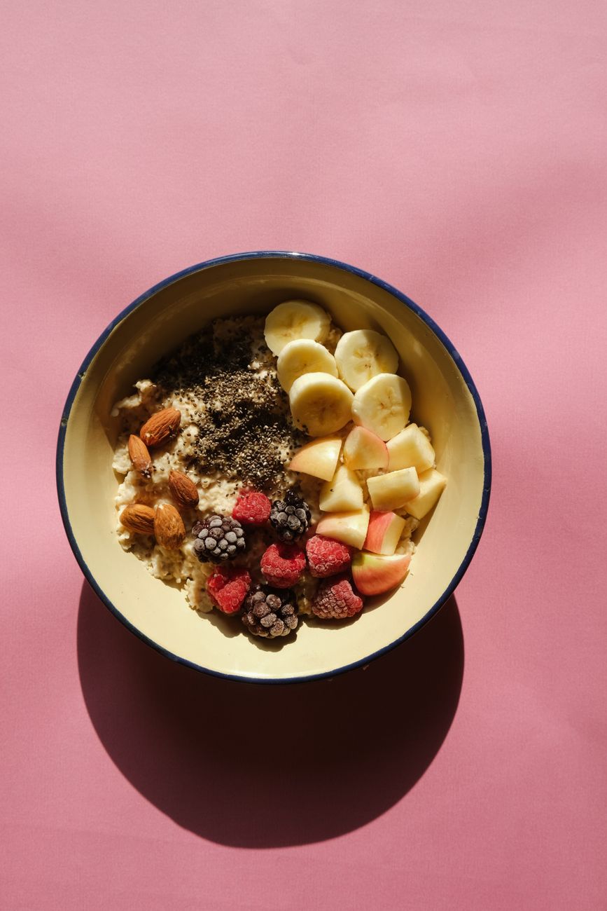 A breakfast bowl with oats, fruit, nuts and seeds, underscoring that baseline fiber intake begins with ordinary meals.