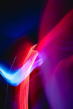 在黑暗的背景上，动态的红色和蓝色灯光条纹构成了充满活力的抽象图像