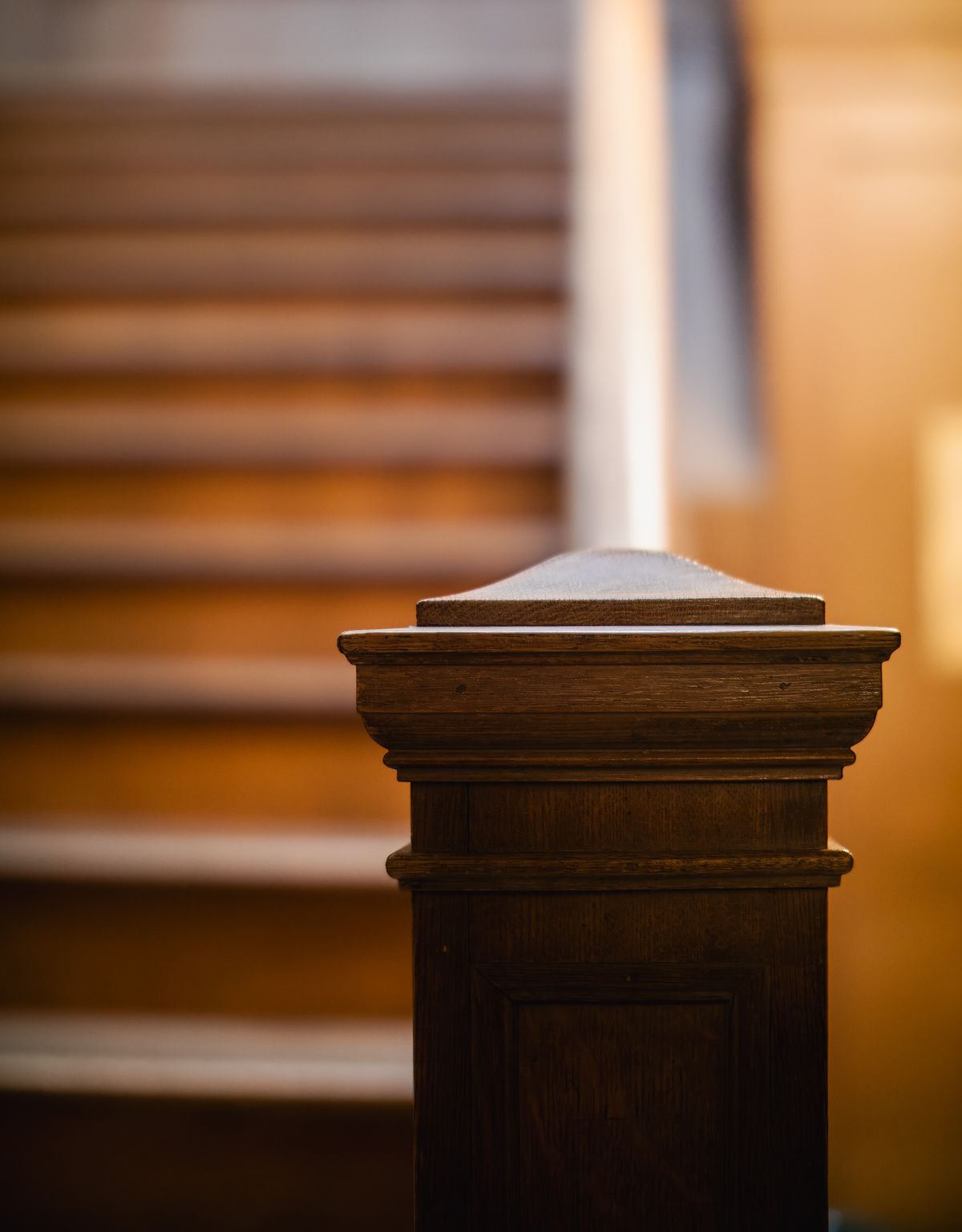 Wooden staircase newel post in warm light
