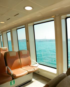 Interior of a ferry in Istanbul, showcasing the Bosphorus with spacious seating and large windows.