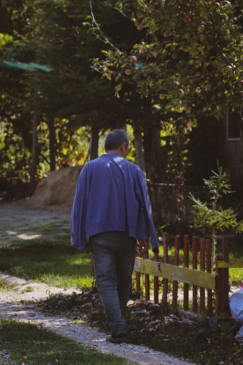 Free A man walking along a rural footpath next to a wooden fence in Eskişehir, Türkiye. Stock Photo