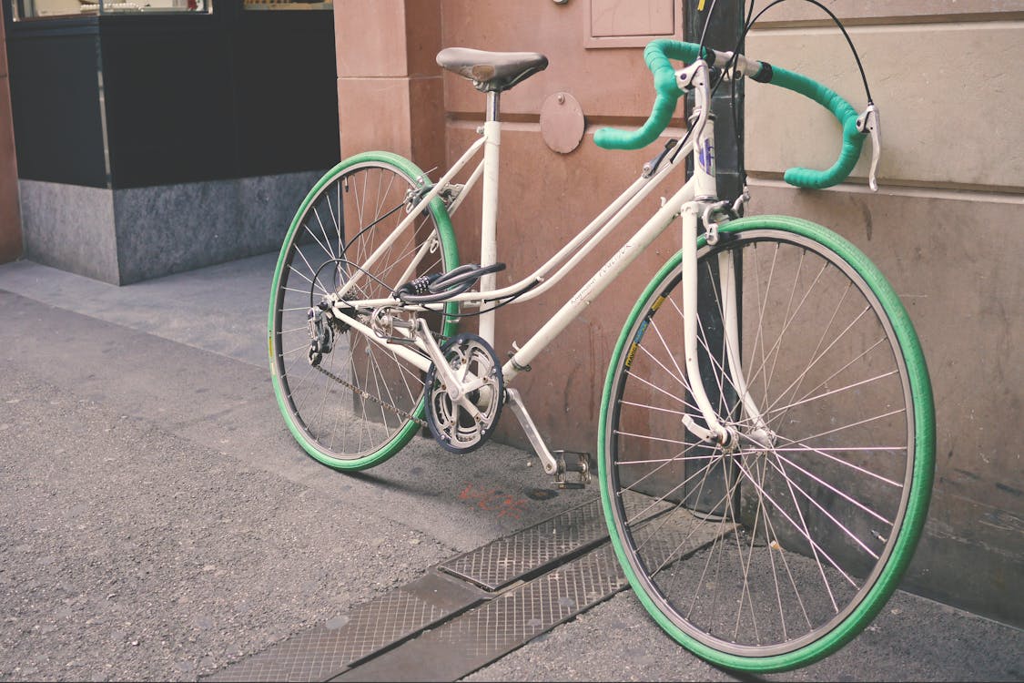 бесплатная бело зеленый велосипед, опираясь на стену Стоковое фото