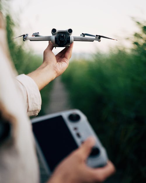 Close-up of a Person Holding a Drone and a Controller