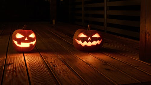 Illuminated Carved Pumpkins Standing on the Floor 