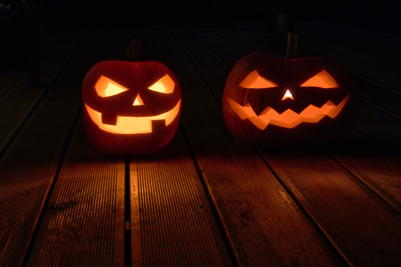 eerie jack o lanterns glowing on a wooden deck for a halloween night