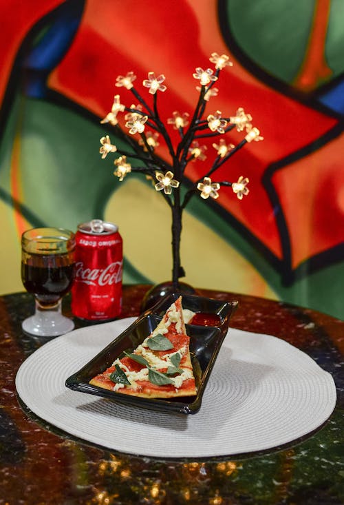 A Slice of Pizza and a Can of Coca-Cola Served in a Restaurant 